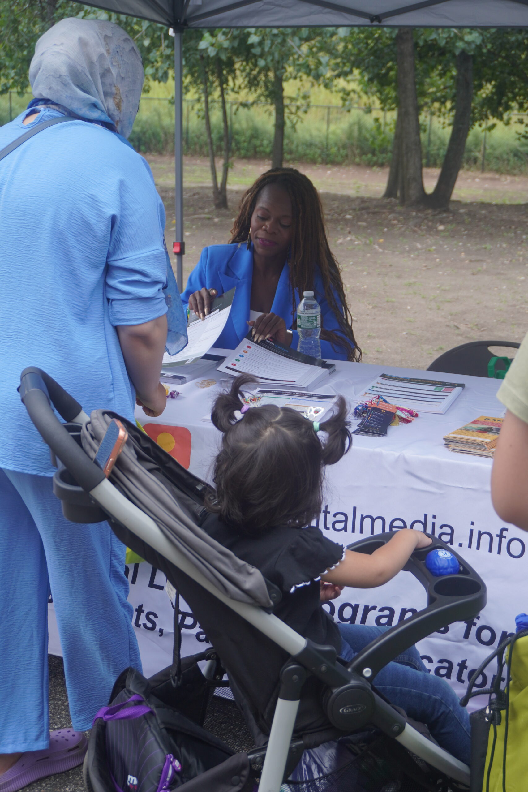 Schnelle Acevedo speaking with a family at the BAM Digital Media table