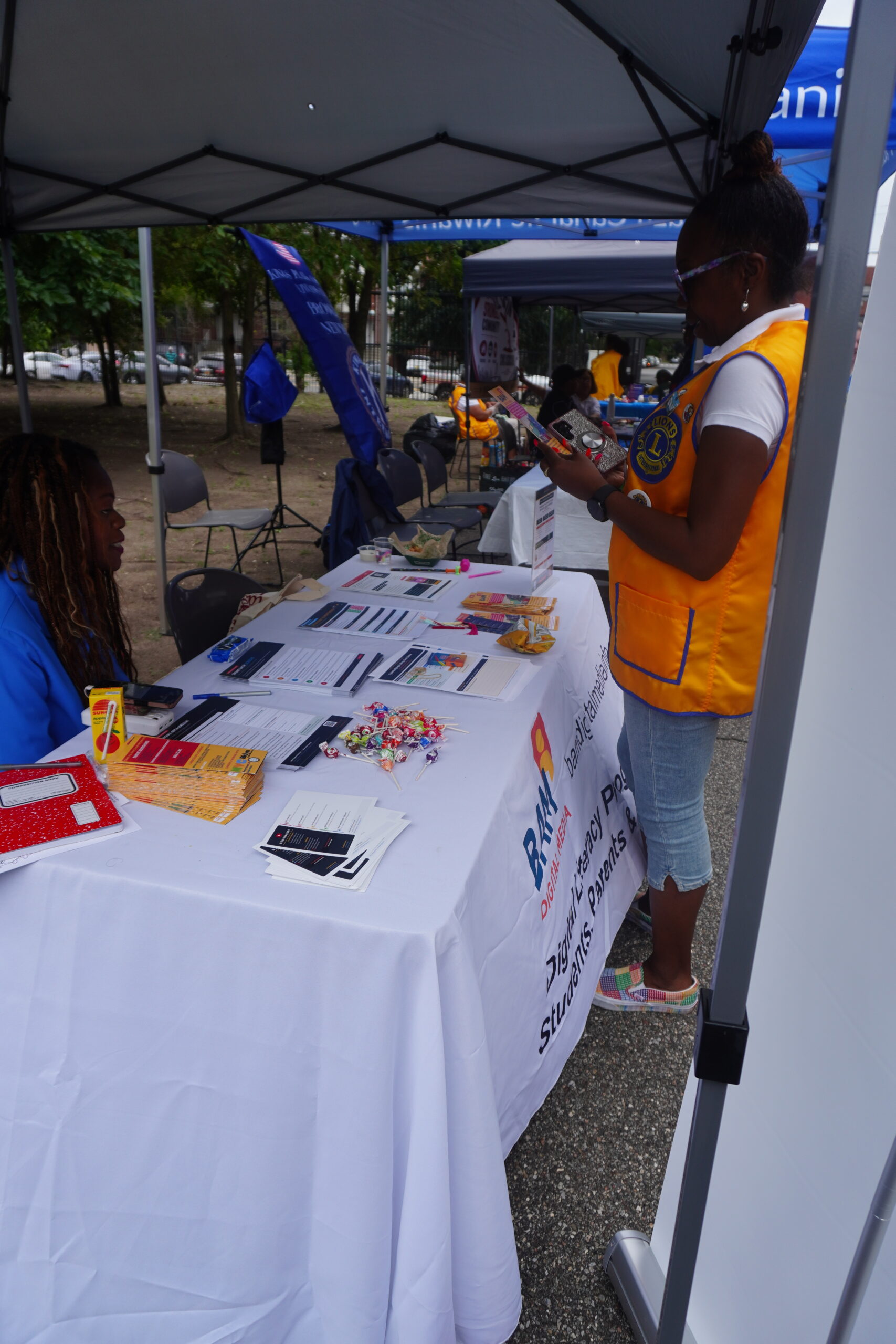 A Lions Club volunteer and a BAM Digital Media table at the community event, side by side with other neighborhood organizations